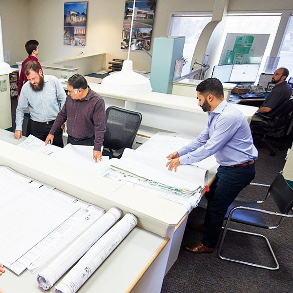 Why WWA Aerial view team members reviewing blueprints